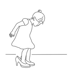 Little girl in a dress is trying on her mother's shoes.