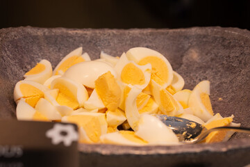  Salad buffet in the restaurant. Bowl with pieces of hard-boiled eggs. 