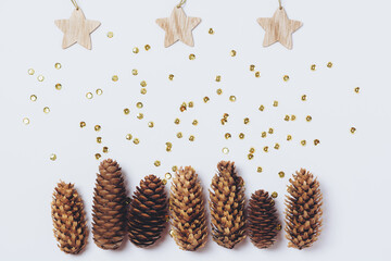 Christmas glitter festive mockup with wood ornaments: pine cones and stars. Zero waste christmas. Layout with a place for an inscription.