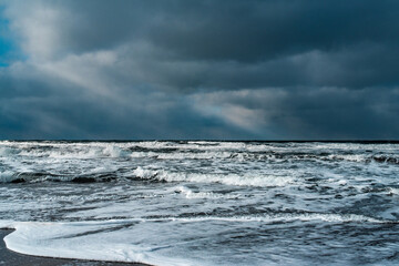 Winter landscape with frozen sea and icy beach. Storm and snow weather. Dramatic seascape.