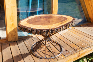 wooden coffee table made of sawn tree slice. Unusual furniture design for your cottage