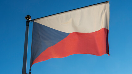 Waving colorful Czech Republic flag on blue sky background. National flag of Czechia.