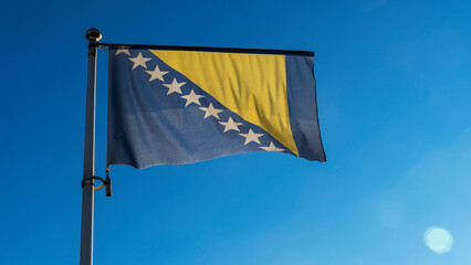 Bosnia Herzegovina national flag waving in the wind on a deep blue sky. Diplomacy and international...