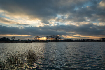 Clouds and sunset over the lake with reeds