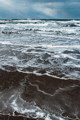 Winter landscape with frozen sea and icy beach. Storm and snow weather. Dramatic seascape.