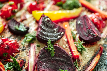 Fototapeta premium Roasted vegetables beets, tomatoes, peppers, carrots, close up. Vegan recipe baked vegetables background. Healthy food concept, Baked vegetables in the oven close-up