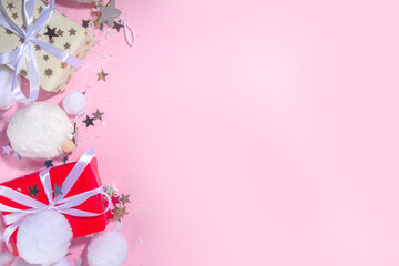 Fluffy Christmas concept. Festive Christmas background with fluffy decoration stuff, xmas ball, gift boxes, with artificial snow and shiny stars on pink color background copy space