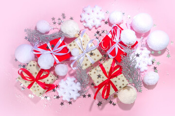 Fluffy Christmas concept. Festive Christmas background with fluffy decoration stuff, xmas ball, gift boxes, with artificial snow and shiny stars on pink color background copy space