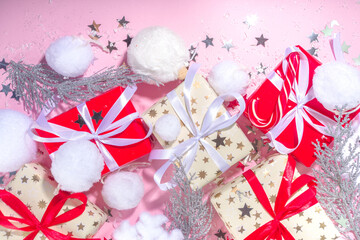 Fluffy Christmas concept. Festive Christmas background with fluffy decoration stuff, xmas ball, gift boxes, with artificial snow and shiny stars on pink color background copy space