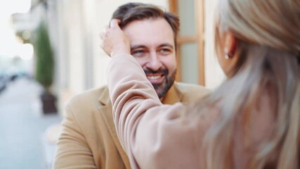 Woman stroking her boyfriend on the head in cafe outdoors