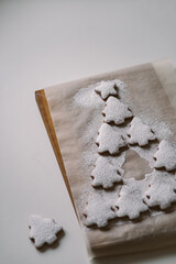 Gingerbread Christmas tree sprinkled with powdered sugar on parchment