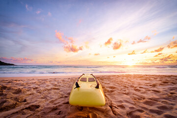 Beautiful landscape. Sunset on the sea beach with lifeguard surf board on sand.
