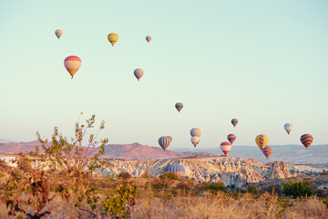 Travel and tourism by Turkey. Famous sightseeing Cappadocia, Anatolia. Beautiful landscape with mountains, caves and baloons in the sky.