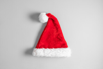 Christmas background. Red santa hat on gray background. Flat lay, top view, copy space