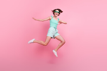 Fototapeta na wymiar Full length body size view of attractive funny cheerful girl jumping having fun isolated over pink pastel color background