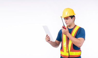 Maintenance workman occupation technology concept. Handsome confident craftsman wear yellow helmet hard hat safety talking with walkie talkie while looking tablet standing over isolated background. - obrazy, fototapety, plakaty