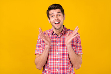 Portrait of attractive delighted cheerful brunette guy clapping palms adore isolated over bright yellow color background