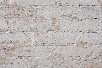 Texture of old white brick wall, there are scuffs, chips and cracks