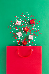 Paper bag with Christmas decorations, gift boxes, confetti. Holiday shopping and sale concept. 