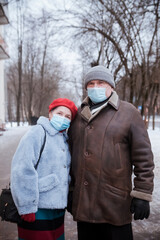 Fototapeta na wymiar Couple of pensioners on street in winter during coronavirus