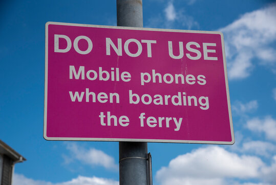 Cornwall, England, UK. 2021.  Do not use mobile phones sign at ferry terminal.