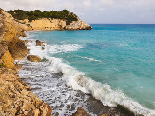 Rocky sandy beach, coastline with turquoise sea, wave splash, Catalonia, Spain