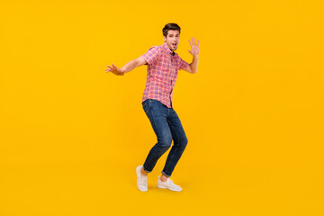 Fototapeta na wymiar Full length body size view of attractive cheerful funky carefree guy dancing having fun isolated over bright yellow color background