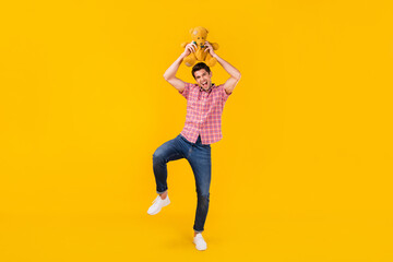 Fototapeta na wymiar Full length body size view of nice carefree cheerful funky guy dancing with toy fooling isolated over bright yellow color background