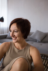 Portrait of a beautiful self-confident woman over 30, she smiles and looks to the side. businesswoman in the room, a moment of relaxation