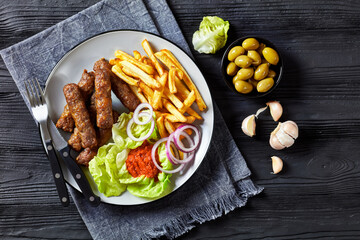 cevapcici with potato fries, lettuce, onion, ajvar