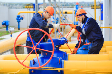 A uniformed worker opens a valve to control gases.
