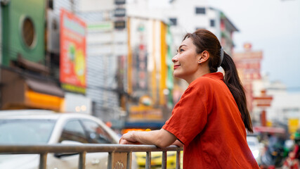 Asian woman walking and shopping at Chinatown street night market in Bangkok city, Thailand. Female tourist enjoy and having fun outdoor lifestyle travel and eating street food in the city at night