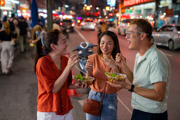 Group of Asian woman and LGBTQ people friends tourist enjoy eating traditional street food bbq...