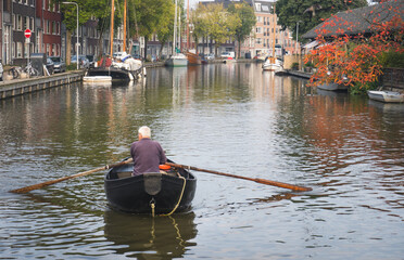 Mężczyzna na łódce płynie po kanale.