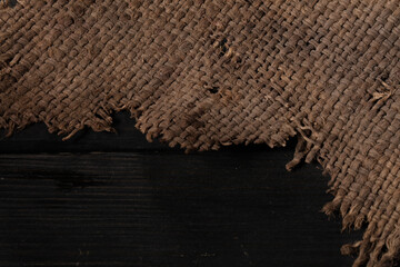Burlap close-up. Rough canvas. Rough weaving fabric background on a wooden background.