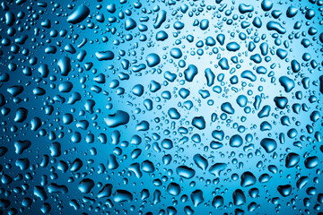 Water drops on glass on a blue background.
