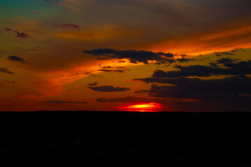Beautiful sunset. The red sun has disappeared below the horizon and fantastic clouds cover the sky.
