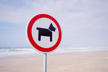 No dogs allowed signal at the beach. Dogs prohibited. Sign that prohibited dogs from entering the beach. Red sign dog prohibition, forbidden dogs.