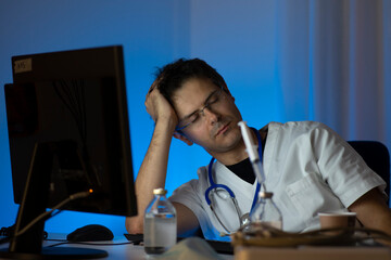 Night shift. Closeup portrait of an health care professional with headache falling in sleep. Nurse or doctor.