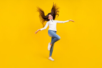 Fototapeta na wymiar Full size photo of pretty brunette teenager girl wear white sweater jeans shoes isolated on yellow color background