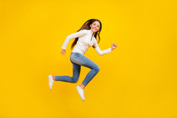 Fototapeta na wymiar Full size profile photo of nice brunette teenager girl run wear pullover jeans shoes isolated on yellow color background