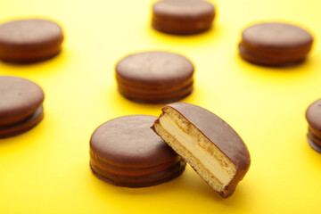 Fototapeta na wymiar Choco pie chocolate coated snacks on yellow background with copy space.