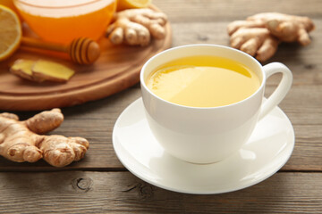 Ginger tea with lemon and honey on grey wooden background.