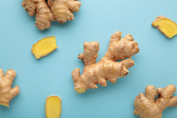 Fresh ginger root on blue background. Vitamins.