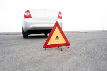 red triangle caution sign on the road as the symbol of car accident on highway