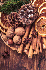Dry orange, star anise, cinnamon, pine cones and fir tree in rustic plate on wooden table. Homemade medley idea for Christmas mood and aroma. Eco friendly christmas with homemade natural decorations.