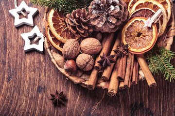Dry orange, star anise, cinnamon, pine cones and fir tree in rustic plate on wooden table. Homemade medley idea for Christmas mood and aroma. Eco friendly christmas with homemade natural decorations.