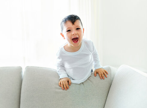 Little crazy boy on living room look like hyperactive