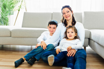 Fototapeta premium Loving mother with kids enjoying time together at home sofa