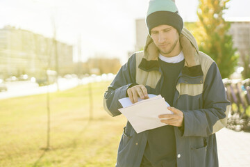 male courier checking the paper documents outdoors, home goods delivery